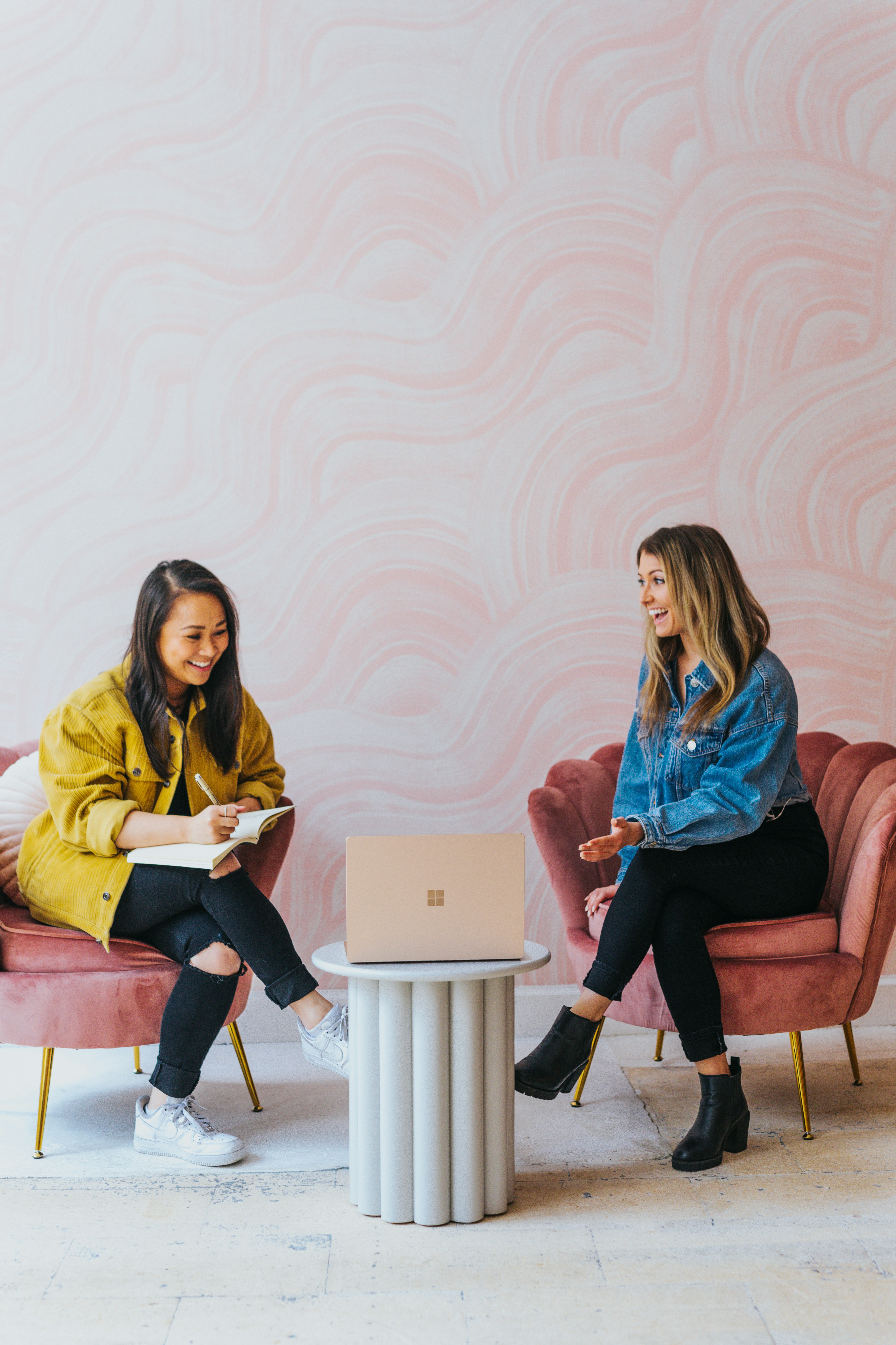 Two female founders in conversation over a laptop